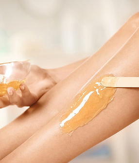 Les jambes d'une femme avec de la cire pour épilation