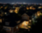 City houses with lights on, more bright outside.jpg