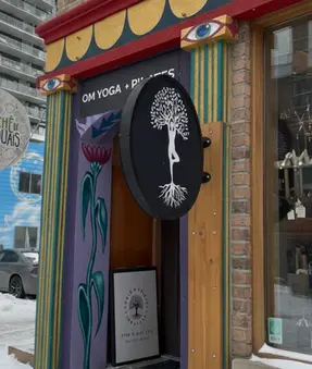 Om Yoga + Pilates outside door with the yoga studio's logo