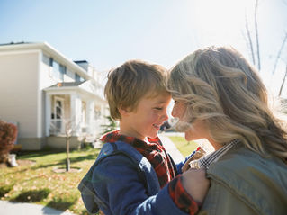 A woman holding her child in a comforting embrace.