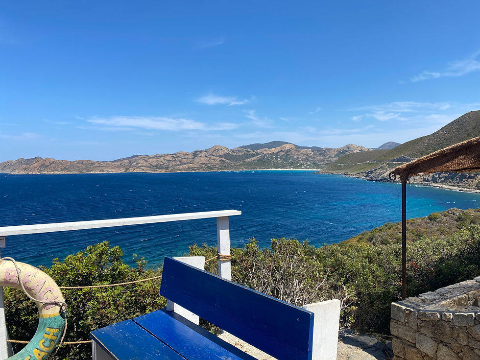 partie de la terrasse avec vue sur la baie et la Mediterranée. un banc bleu simple en 1er plan