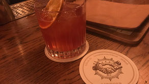 verre posé sur le comptoir du bar avec un dessous de verre au nom de l'enseigne