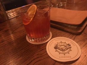 verre posé sur le comptoir du bar avec un dessous de verre au nom de l'enseigne