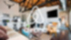 A modern loft with wood beams, a kitchen, and seating area. A large TV, stag head, and "Airbnb" logo are visible, creating a cozy vibe.