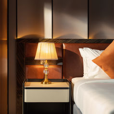 Cosy twin bedroom cabin on Luna Halong Cruise with bedside lamps, wooden flooring and Halong Bay view