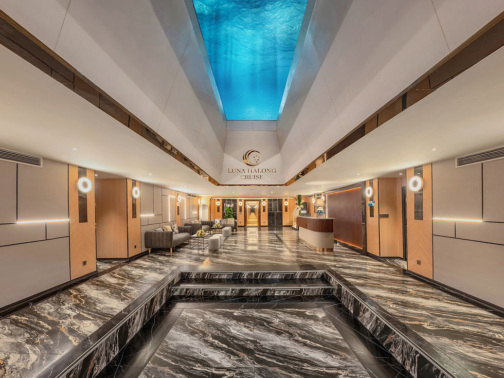 Modern cruise lobby with marble floors, blue wave-like ceiling, sofas, and reception desk; sign reads LUNA HALONG CRUISE