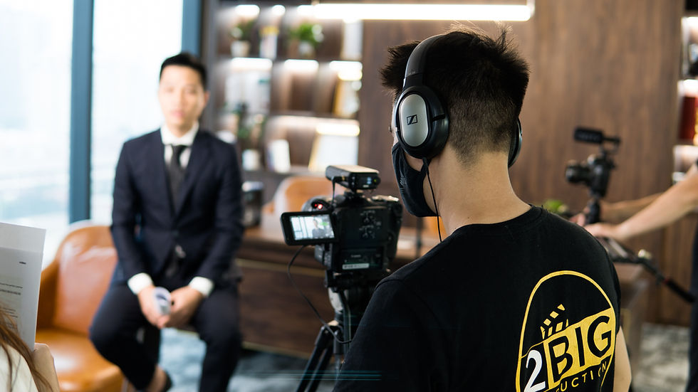 behind the shoulder of a camera operator filming an interview