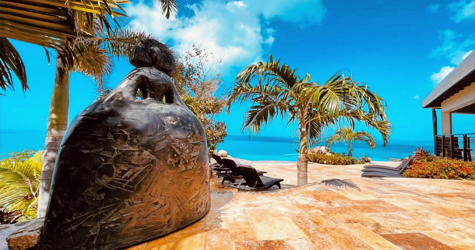 Outdoor lounge area with tropical plants and ocean scenery - Tortola villa.