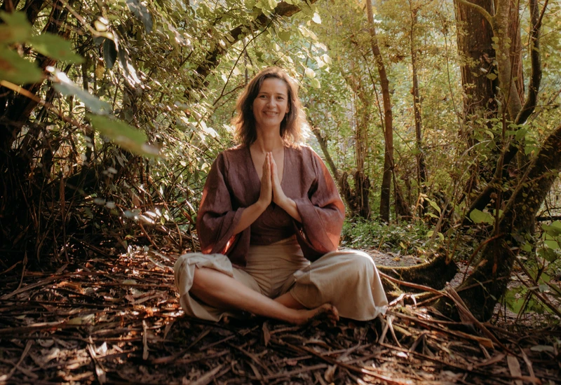 woman sitting in a yoga pose in the forest