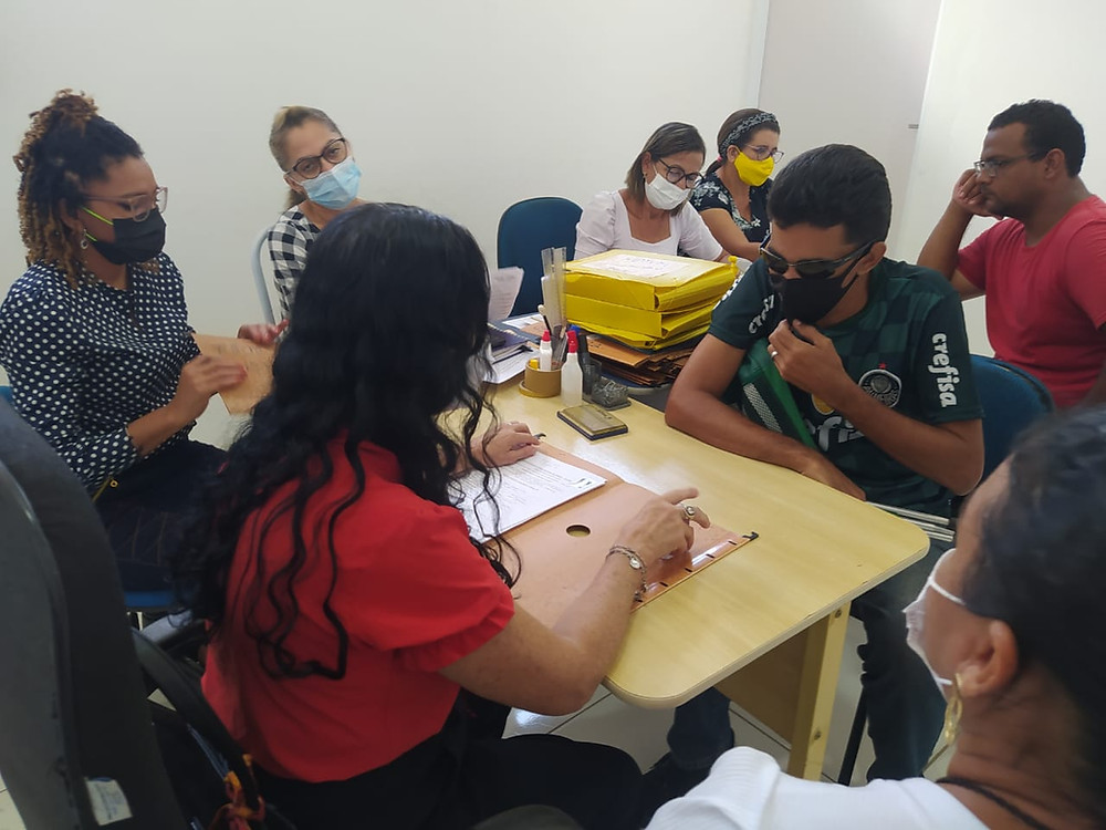 Pessoas realizam entrevista cadastral em uma sala de escritório