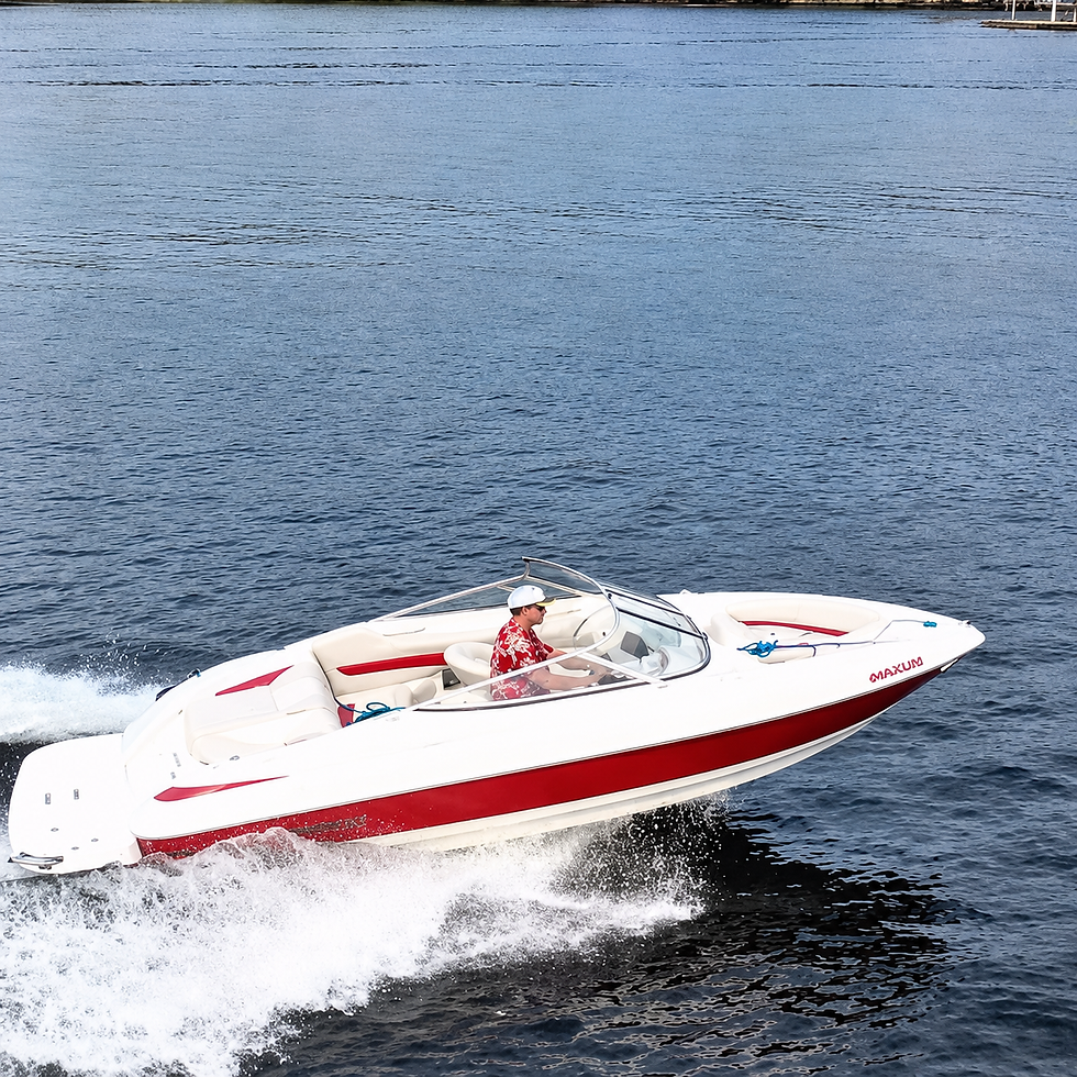 A white and red speedboat on Lake Muskoka with a person in a red shirt driving, wide landscape, blue water background.
