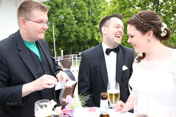 Zauberer unterhält Brautpaar bei der Hochzeit im Freien