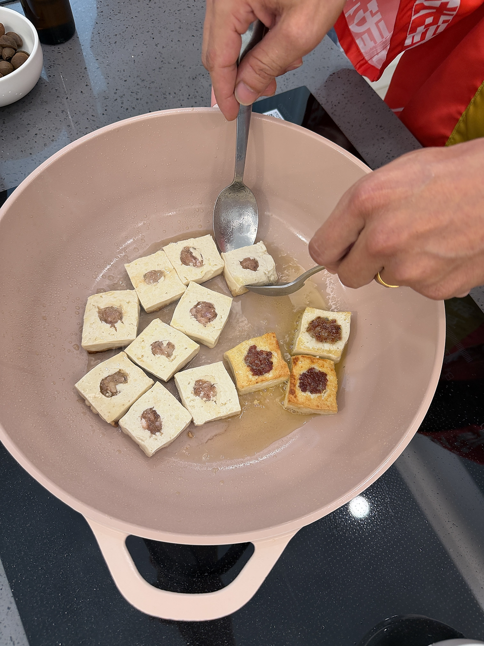 4. 將豆腐推至鍋邊,利用餘油下蒜末爆香。沿鍋邊淋入 武雄丸大豆醬油15ML,接著加入水、米酒與紅糖,轉中火蓋鍋蓋煨煮 3 分鐘讓豆腐入味。