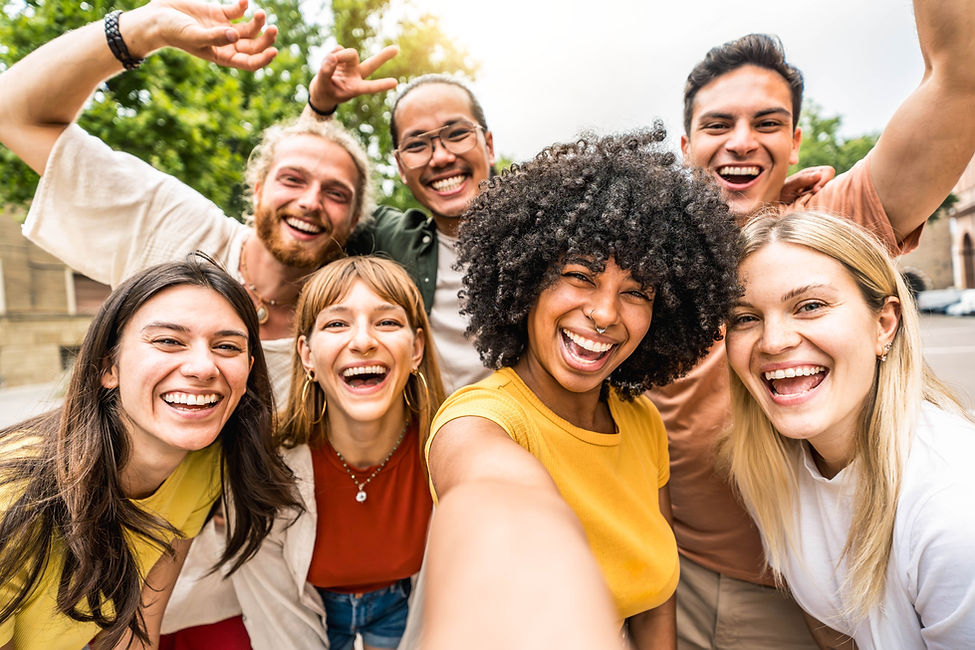 Multicultural friends smiling at camera together outside - Happy young people taking selfi