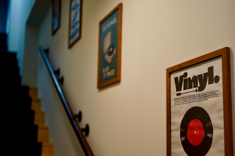 Interior corridor at KAOL MUSIK with framed vinyl posters and warm lighting.