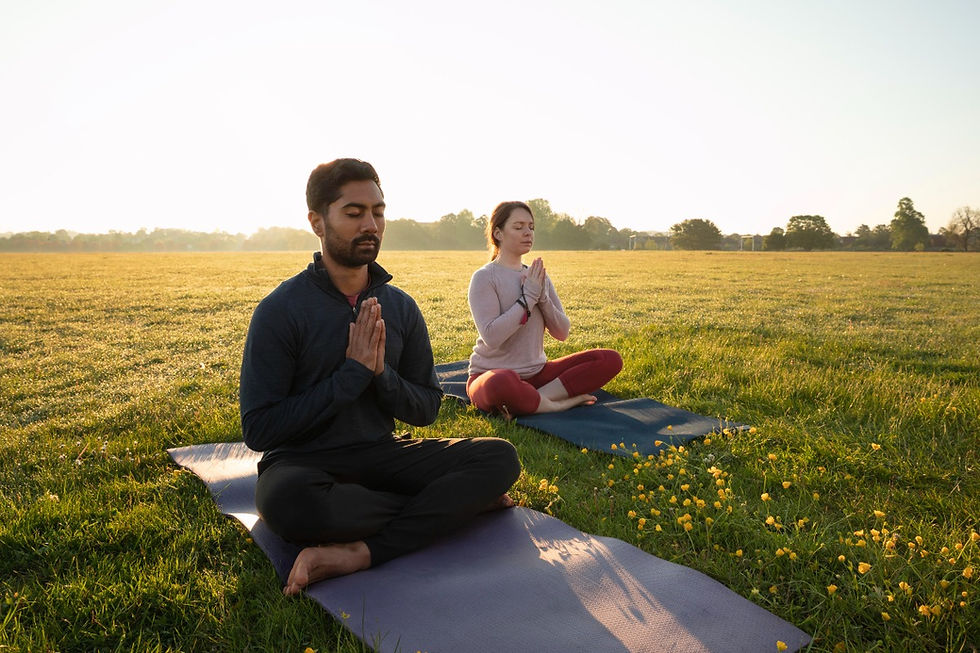 Man and woman doing Bhastrika Pranayama at sunrise in a park