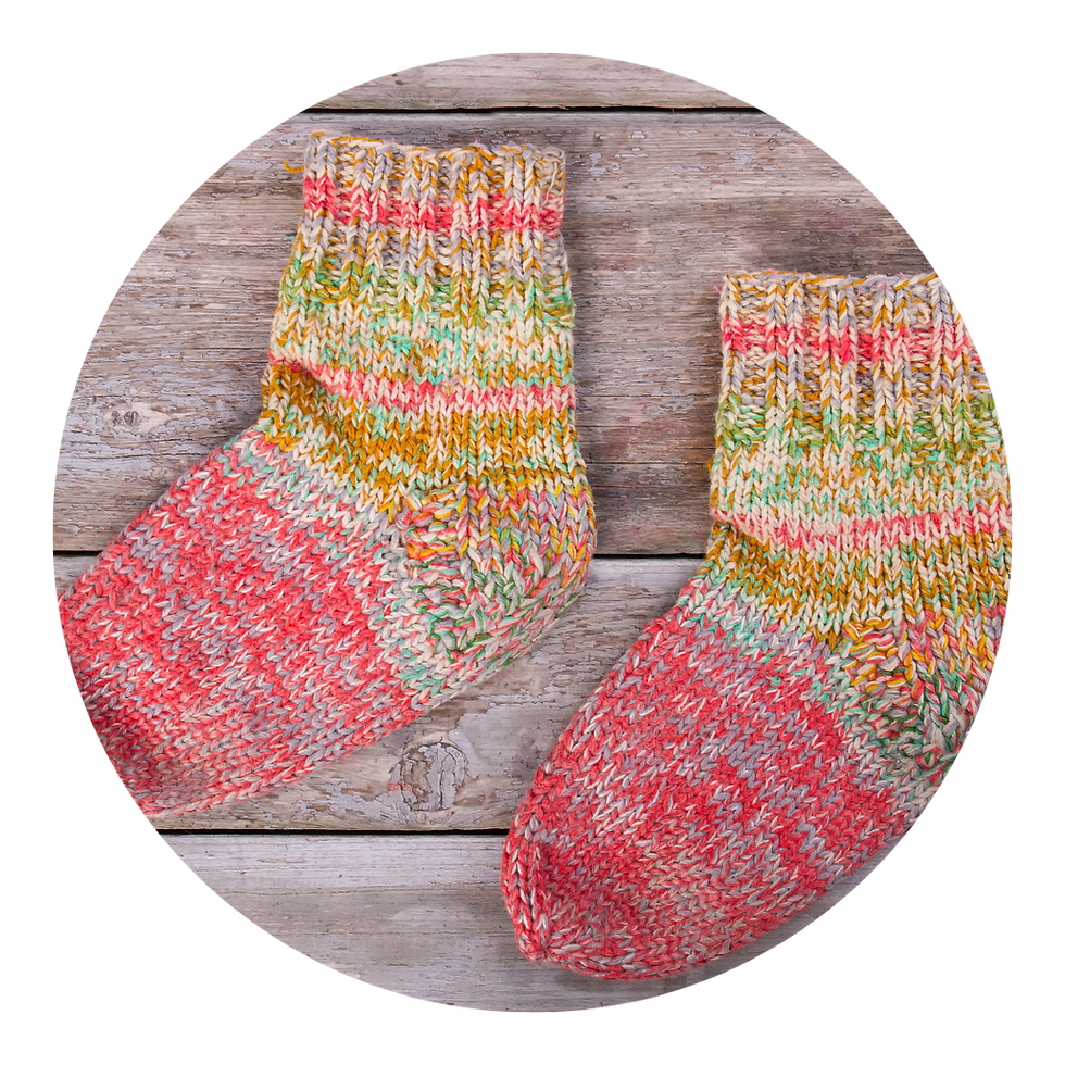 Knitted wool baby socks on a wood floor