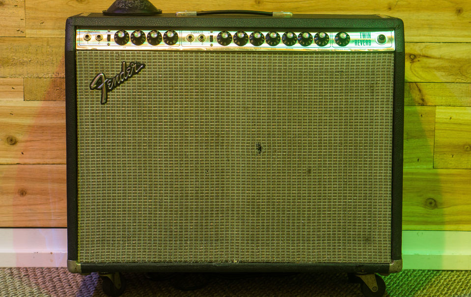 Vintage tube guitar combo amp with a silver "Fender" logo badge labeled "Twin Reverb" in blue.