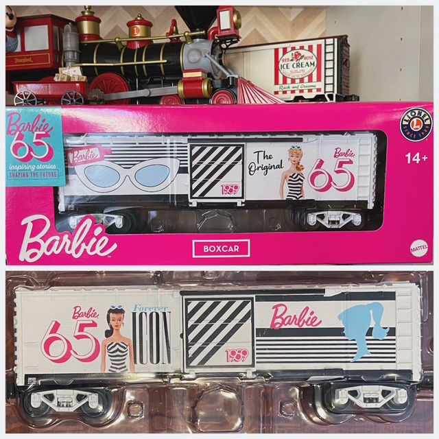Both sides of the Barbie x Lionel boxcar. One side of the white with black stripes car features the Blonde number 1 doll and the other has the brunette.