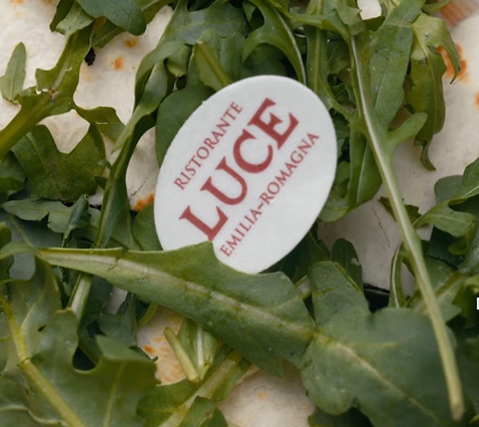 Cialdina ovale personalizzata su piatto con rucola