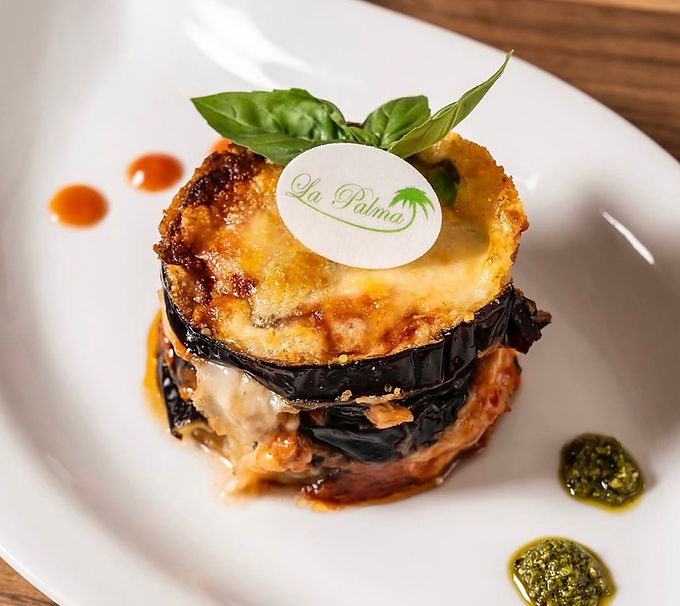 Cialdina ovale con logo su parmigiana di melanzane
