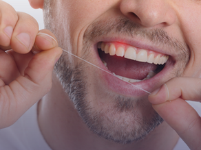 Homem passando fio dental e sentindo dor
