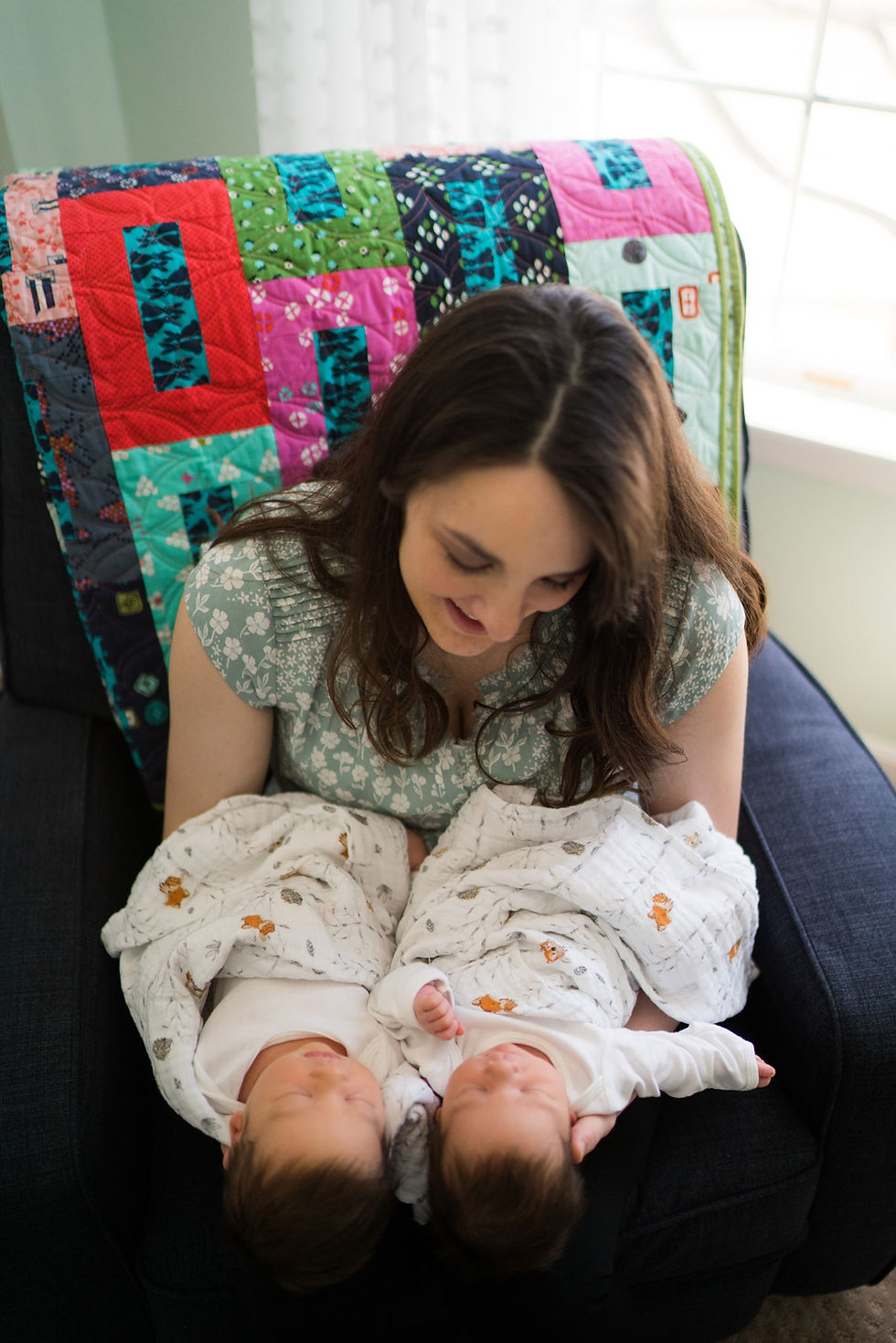 Mom holding twin newborns