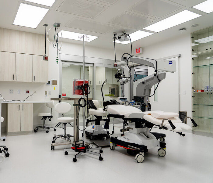 Bright, modern ophthalmic surgery suite with advanced equipment and clean white cabinetry, landscape aspect ratio.