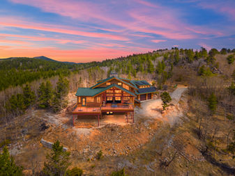 Off-grid mountain cabin near Idaho Springs Colorado with panoramic Front Range views from a large wraparound deck at 10,000 feet elevation.