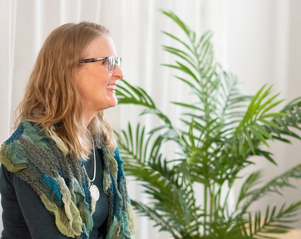 Lea Appleton wearing a teal sweater and blue and green scarf speaking at the She Stories event.