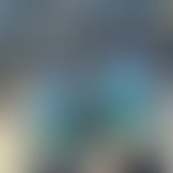 Lea's feet wear gray hiking shoes with bright aqua laces standing on cement next to gravel.