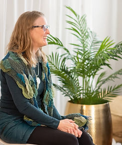 Lea Appleton with hands in her lap looking out at audience (not shown) and smiling.