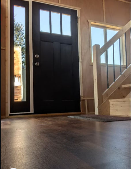 Close-up view of a tiny home's interior showing wood finishes and minimalist furniture