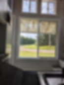 Thumbnail: Window view from a tiny home overlooking a green field.