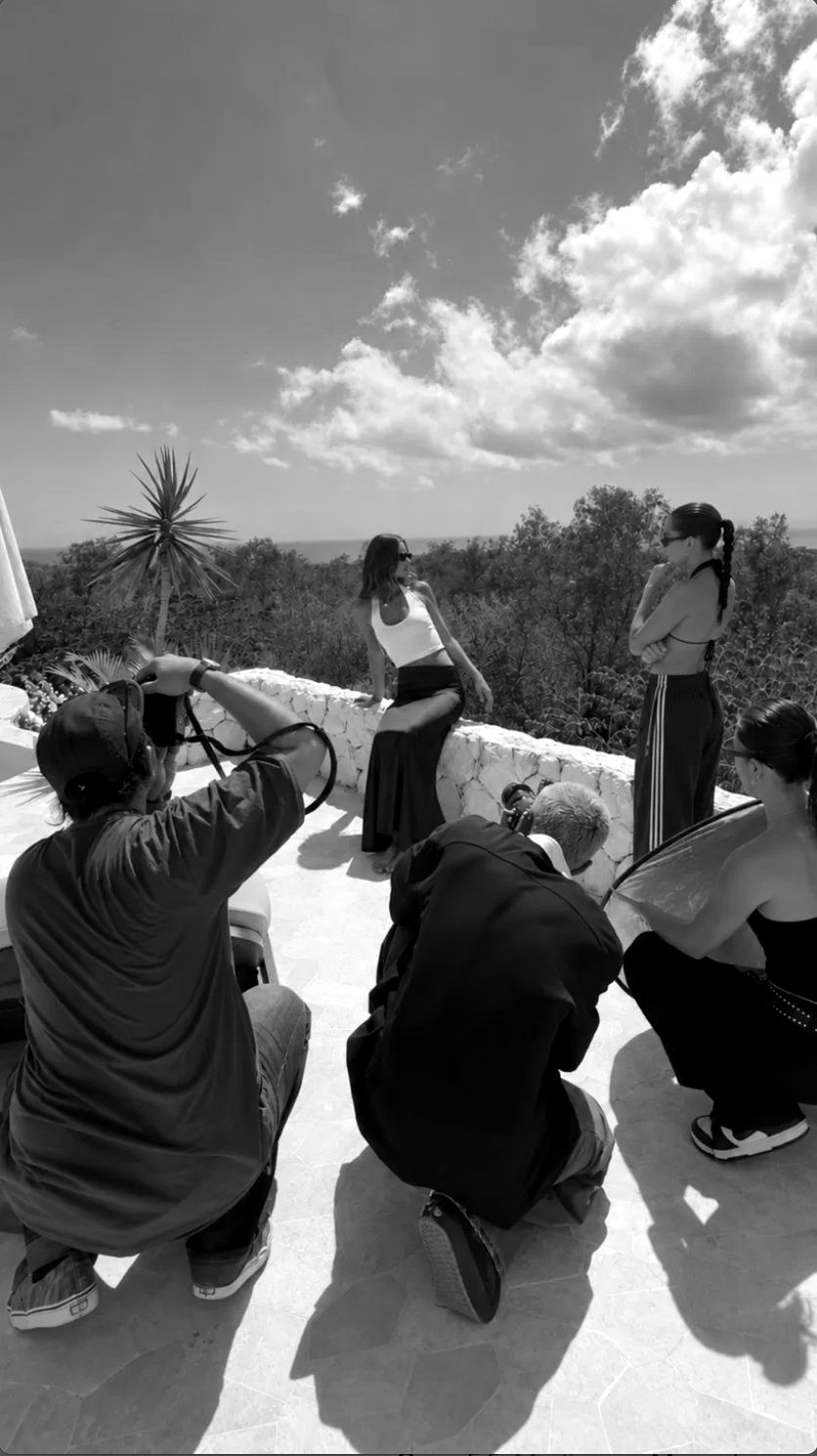 Behind the scenes of an outdoor fashion shoot, photographers and crew working with models on a terrace, The Image Studio production