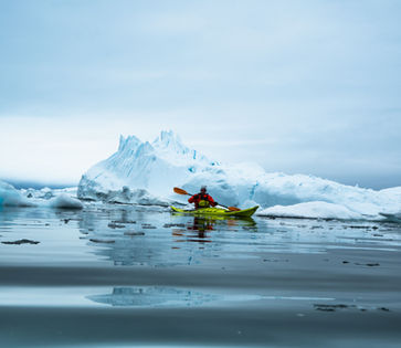 Person Kayaking in the sea next to Greenland