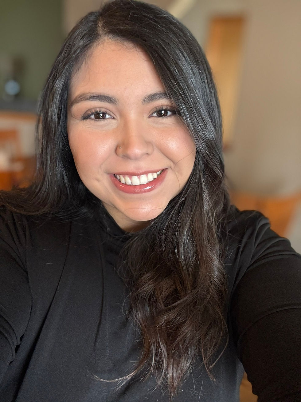 Smiling woman with long dark hair wearing a black top.