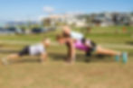 Bek Nutter, naturopath, and her children doing exercise in the park near newcastle beach nsw