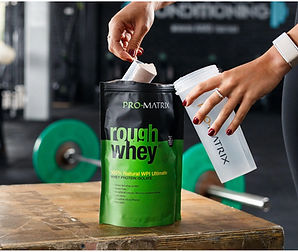 Athlete scooping out some Promatrix Protein Powder into their shaker