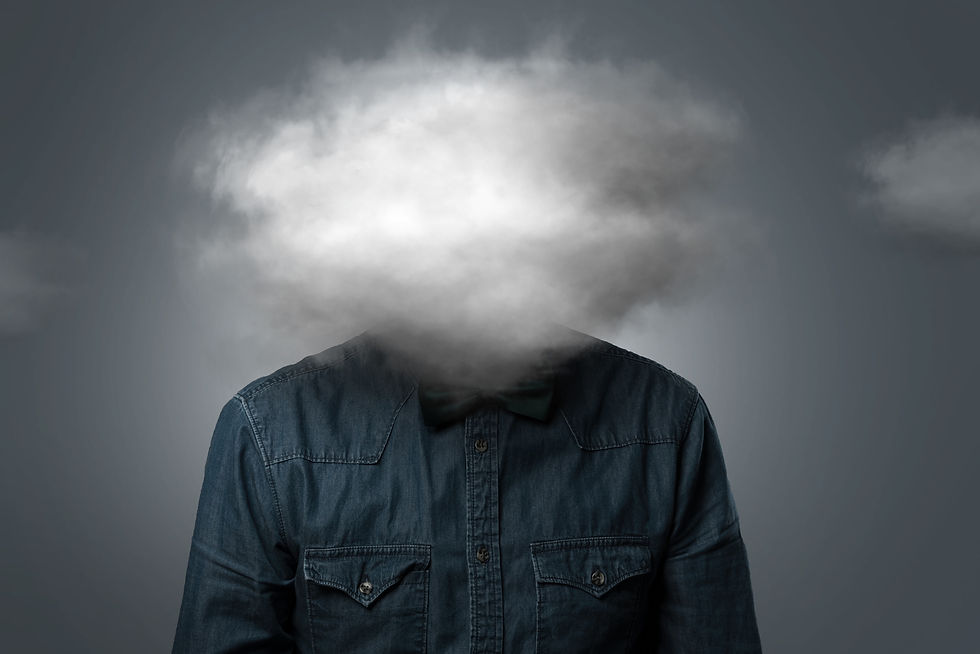 Person in a denim shirt with a cloud obscuring their head, set against a gray background, giving a surreal, introspective mood.