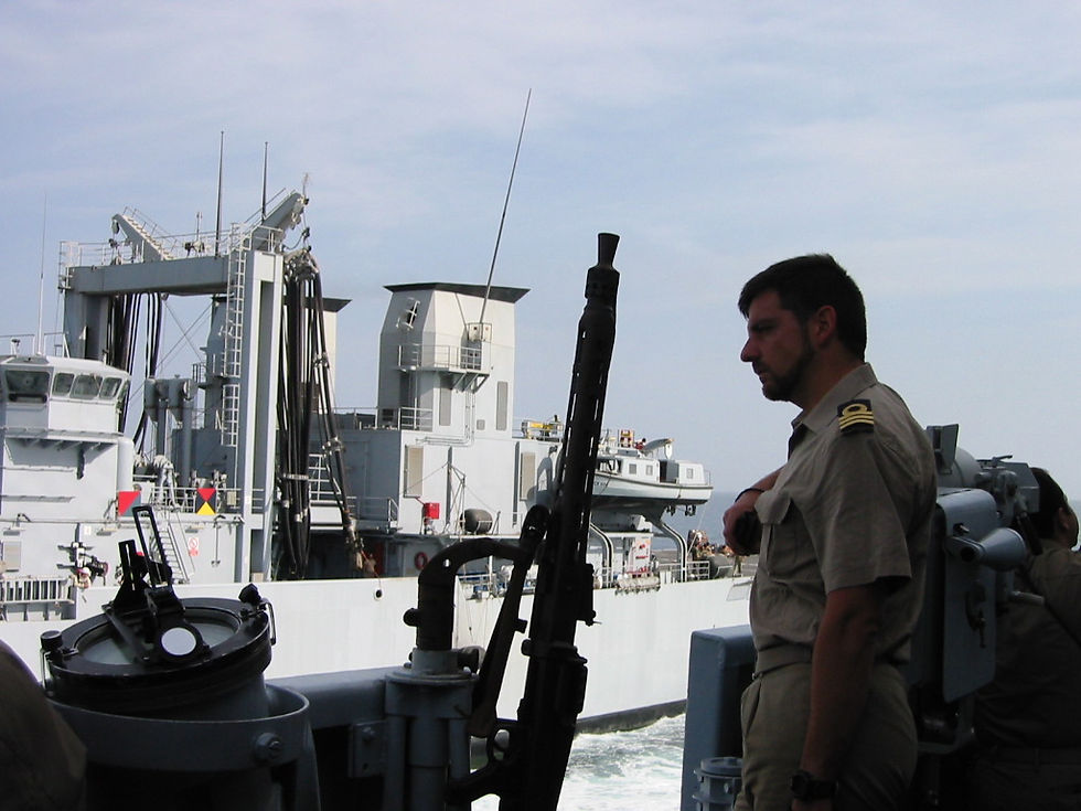 Stefano on the bridge wing of a military ship when he was the Navigator, in charge of planning the routes and steering the ship on some particular occasions. Stefano is observing a replenishment at sea maneuver, performing his leading role with competence