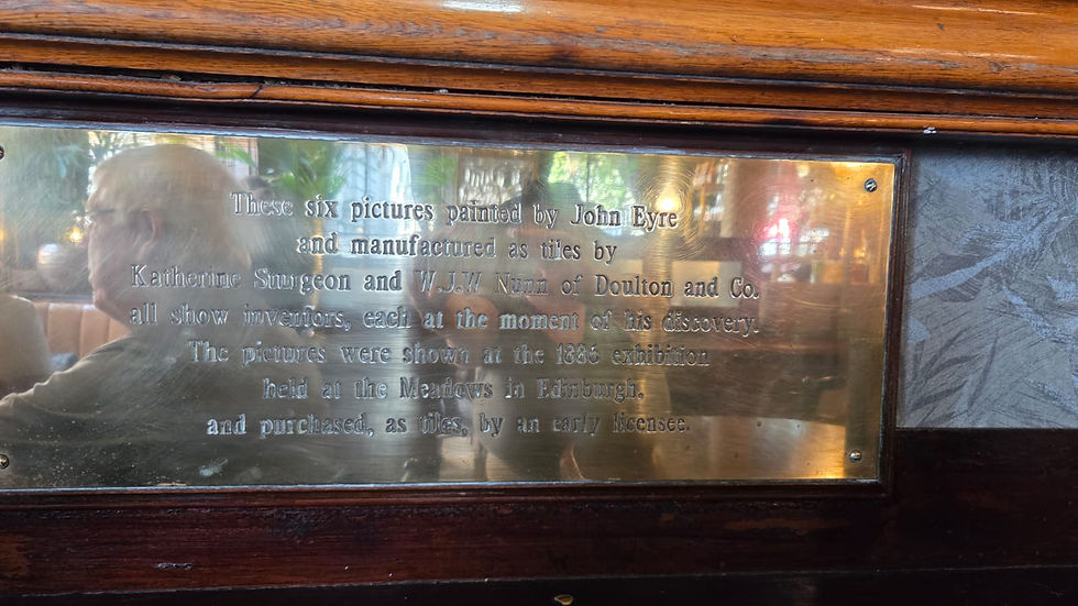 The brass plaque explaining the Doulton tile panels: painted by John Eyre, made into tiles by Katherine Sturgeon and W.J.W. Nunn of Doulton & Co, shown at the 1886 Edinburgh exhibition