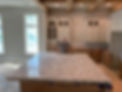 Luxury kitchen under construction featuring a massive marble island with stunning natural veining, expertly fabricated and installed by JV Precision Countertops. The space showcases custom cabinetry, a farmhouse-style sink, and an open-concept layout, perfect for modern living. The high-end stone countertop provides durability, elegance, and ample workspace for cooking and entertaining. Recessed lighting enhances the sleek design, while the unfinished cabinetry highlights the precision craftsmanship in progress. Ideal for homeowners looking for premium marble countertops, custom installations, and expert craftsmanship from JV Precision Countertops.