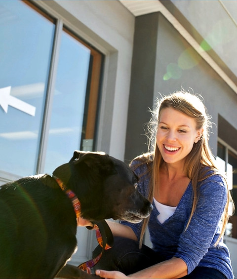 Woman with dog in front of kennel
