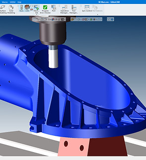 CNC machine cutting a blue component, computer screen in the background