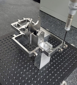 Metal part being inspected by a machine in a manufacturing facility setting.