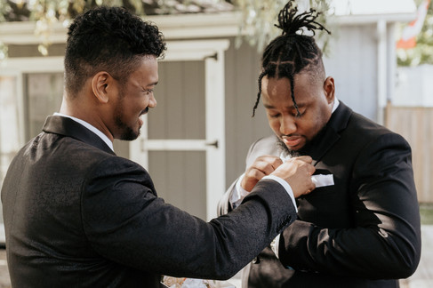 groom helping best man with his boutonniere