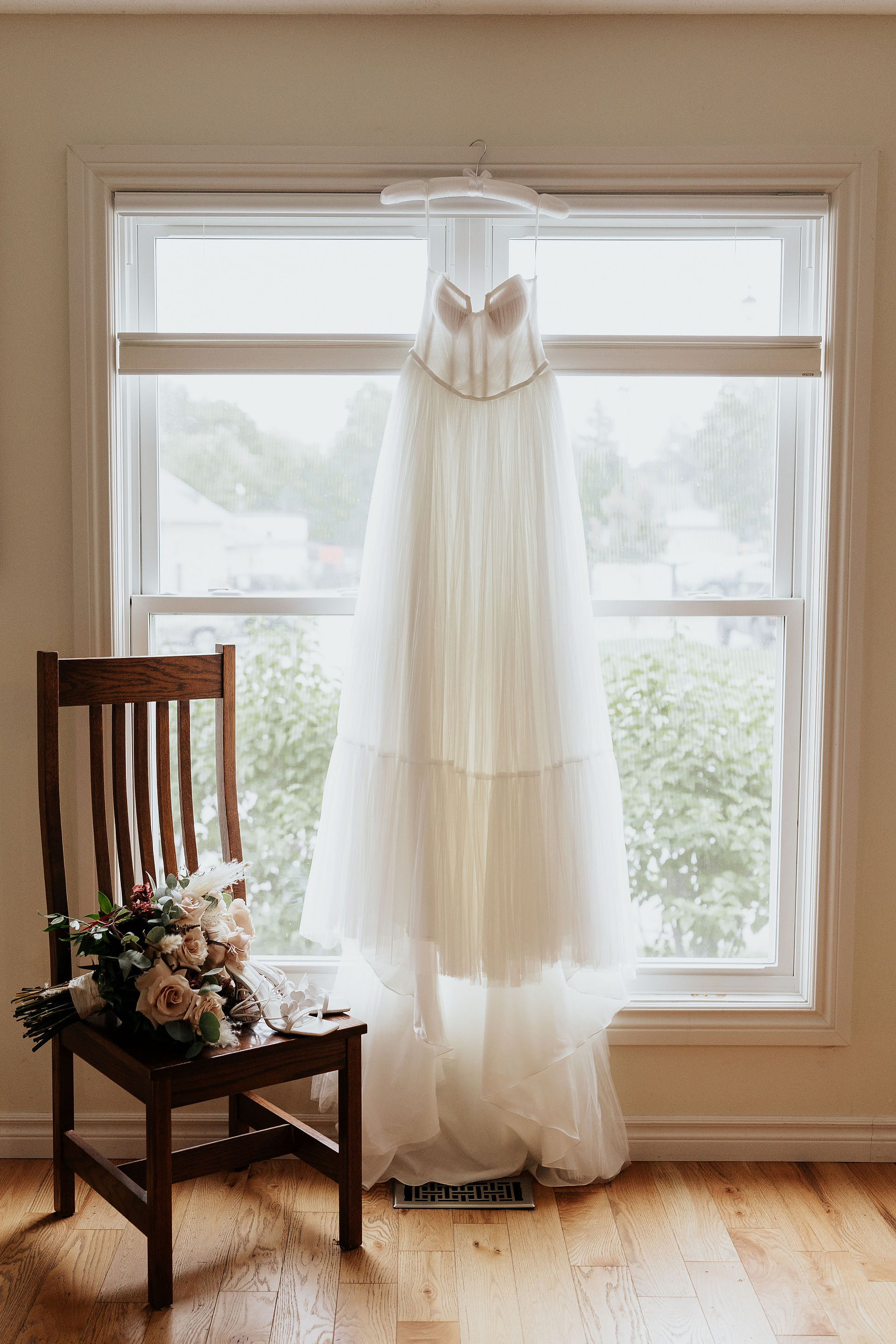 brides dress hanging with flowers