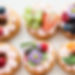 Photo of donuts adorned with halo of fruits and flowers.