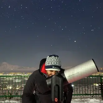 Photo of an Armenian hobby astronomer looking through a Unistellar telescope near Yerevan, Armenia